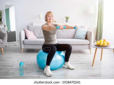 Lovely mature woman sitting on fitness ball, working out with dumbbells in her home gym, empty space. Attractive senior lady taking care of her health, exercising indoors. Active lifesyle concept - Powered by Shutterstock