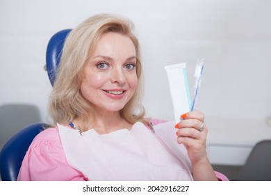 Lovely Mature Woman Smiling, Holding Toothbrush And Toothpaste