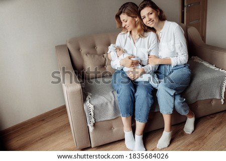 Similar – Mother giving bottle to her newborn