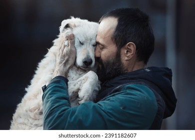 Lovely moment when mature man holding and hugging cute abandoned dog in shelter. Love, care and tenderness - Powered by Shutterstock