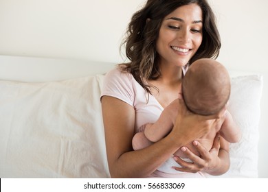 Lovely Mother Holding Newborn Baby In Arms