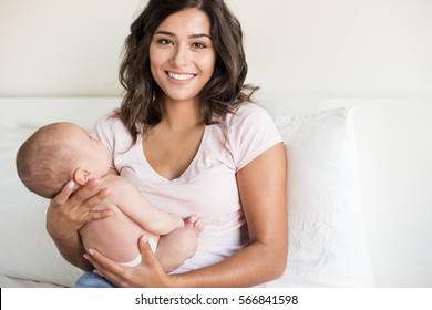 Lovely Mother Holding Newborn Baby In Arms