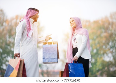 Lovely muslim couple taking a walk after shopping. concept