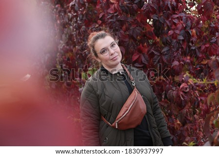Lovely red-haired woman posing on an autumn walk