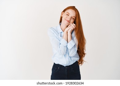 Lovely Redhead Girl With Long Ginger Hair Dreaming, Close Eyes And Leaning On Hands, Imaging Something Romantic With Heartfelt Smile, White Background.