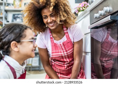 Schöne Szene einer Mutter und Tochter, die Essen in der Küche zubereitet, die rassische Familie zu Hause kochen