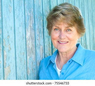 Lovely Seventy Year Old Woman Smiling In Blue Shirt With Copyspace Or Room For Your Words Or Text