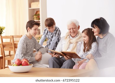 Lovely, smiling family looking at old photographs