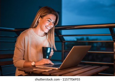 Lovely Smiling Woman Using Laptop At Night.