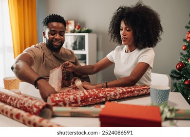 A lovely snapshot of an african american couple exchanged smiles while wrapping gifts for the holiday season. The colorful decorations and tree reflect the festive cheer around them. - Powered by Shutterstock