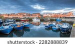 A lovely still morning with the colourful boats reflected in the harbour at Seahouses on the Northumberland coast, England