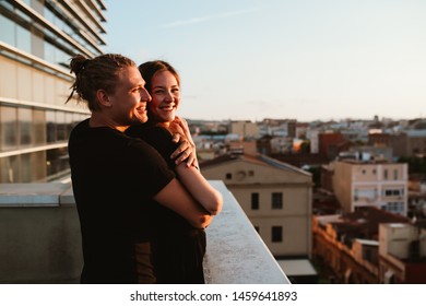 Lovely sweet happines couple sit on the roof top with amazing sunset view on the urban city town. They love each other hugs very tenderness sun goes between hair.Hipster millenial boyfriend girlfriend - Powered by Shutterstock