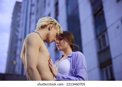 A lovely teenage couple is hugging and snuggling outside in an urban exterior surrounded by buildings and skyscrapers. - Powered by Shutterstock