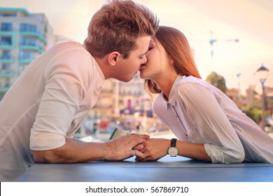 Lovely Teenagers Kissing By The Table