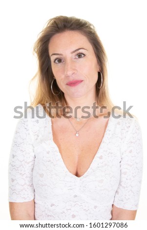 lovely woman with blonde hair face looks at camera wears white casual clothes poses in studio background