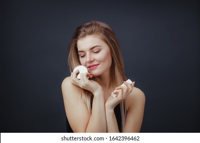 Lovely Woman With Natural Makup And Smooth Healthy Skin Holding Jars Of Beauty Products