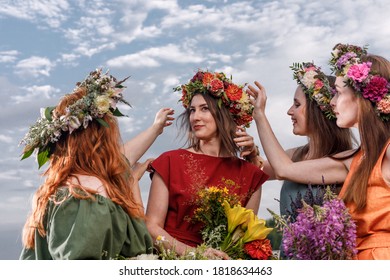 Lovely women's in flower wreaths in nature. Ancient pagan origin celebration concept. Summer solstice day. Mid summer. - Shutterstock ID 1818634463