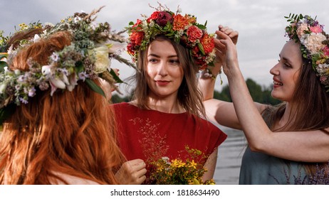 Lovely women's in flower wreaths in nature. Ancient pagan origin celebration concept. Summer solstice day. Mid summer. - Shutterstock ID 1818634490
