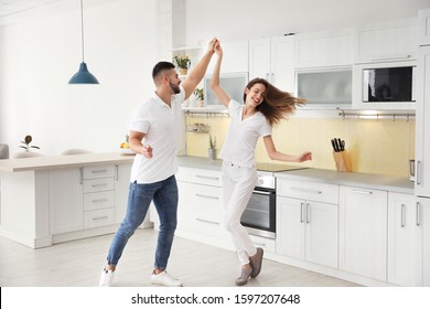 Lovely Young Couple Dancing In Kitchen At Home