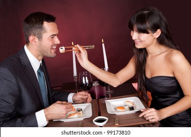 Lovely Young Couple Eating Sushi In Restaurant