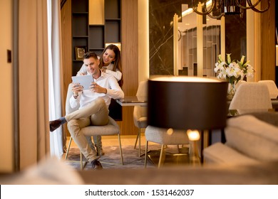 Lovely young couple relaxing at luxurious home with digital tablet