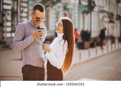 Lovely Young Couple Walking At Old City Town, Smiling, Kissing, Drinking Coffee And Have Fun Together