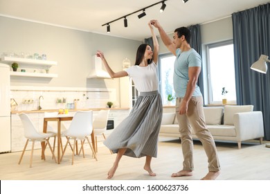 Lovely young interracial couple dancing at home
