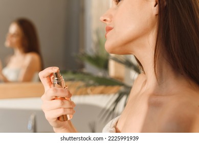A lovely young woman uses a moisturizing mist spray for glowing skin. Moisturizing, home care and spa concept.