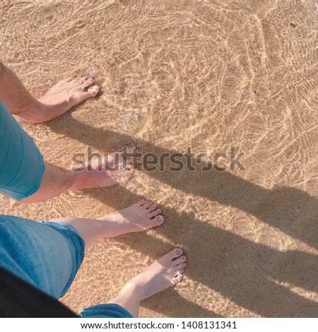 A lover with feet in the water at the beach