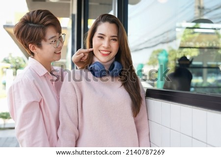 lover LGBTQ teasing each other while relaxing in front of coffee in the urban                               