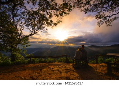 The lover sitting under the trees and seeing sunset. This is the most beautiful and romantic scene between nature and couple.