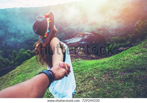 恋人の女性や男性のアジア人は 休日にのんびり旅をします 芝生を走る手を握って 山の上の野生の木 の写真素材 今すぐ編集