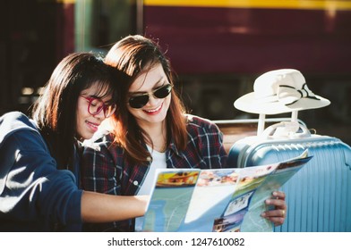 Lovers Of Asian Women Lesbian LGBT Couples, View Map On Old Bench In Platform Of Train Station, Concept Of Travel Holiday Pleasure, Shopping And Planning For Summer Train Travel  In Asia