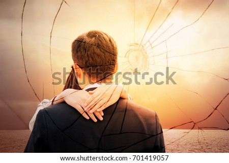 Lovers back hugging over dramatic sunset sky background.Sad young couple in relationship difficulties. Broken heart or divorce concept, double exposure. Break off, withdraw, disengage one's engagement
