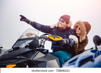 Lovers. Guy And Girl On A Snowmobile. Concept Winter Vacation For Family. Shine Of The Sun.