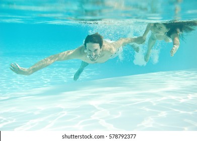 Lovers guy and girl swim underwater in the pool - Powered by Shutterstock