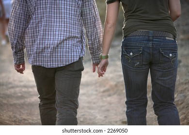 Lovers Holding Hands While Walking