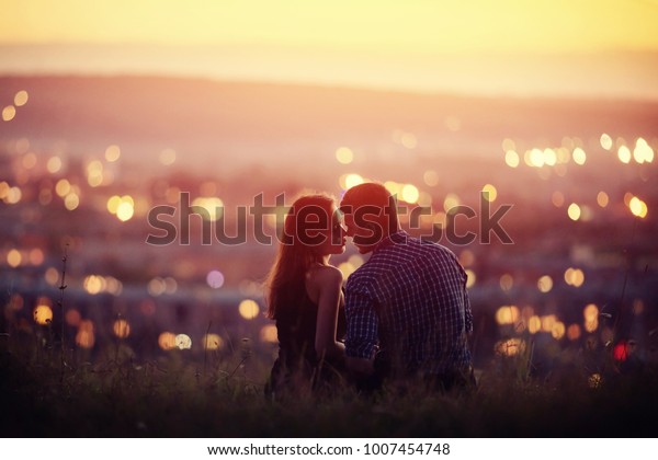 Lovers man and girl against background night city, sky and horizon. Concept date Valentine Day, first kiss love
