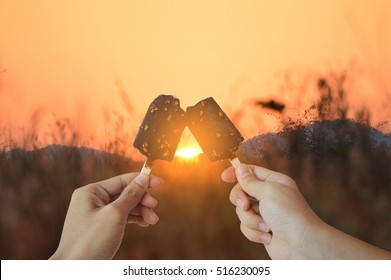 Lovers man and woman are enjoy while eating ice cream at the sunset. Sweet Love Moment