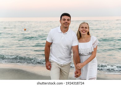 Lovers Near The Ocean Hug And Have Fun. Husband And Wife Hugs At Sunset Near The Sea. Lovers On Vacation. Summer Rest. Romantic Walk By The Ocean