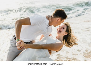 lovers near the ocean hug and have fun. husband and wife hugs at sunset near the sea. lovers on vacation. summer rest. romantic walk by the ocean - Powered by Shutterstock