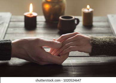 Lovers in a romantic table holding hands. Valentine's Day. A woman and a man spend candles in the evening together.