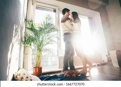 Lovers Standing Near The Window, Looking To Each Other And Kissing. Magic Light.