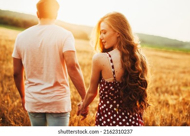 Lovers walking hand in hand in autumn field. Back view. Love, dating. Wheat field. - Powered by Shutterstock