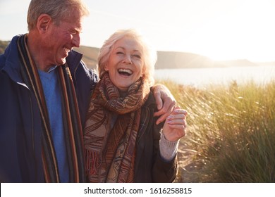 Loving Active Senior Couple Hugging As They Walk Through Sand Dunes - Powered by Shutterstock