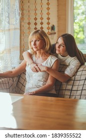 Loving Adult 20s Daughter Hug Elderly Mother From Behind While Mom Sitting On Couch People Posing Looking At Camera Smiling Feels Happy, Concept Of Multi Generational Family, Relative Devoted Person