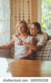 Loving Adult 20s Daughter Hug Elderly Mother From Behind While Mom Sitting On Couch People Posing Looking At Camera Smiling Feels Happy, Concept Of Multi Generational Family, Relative Devoted Person