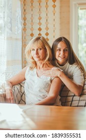 Loving Adult 20s Daughter Hug Elderly Mother From Behind While Mom Sitting On Couch People Posing Looking At Camera Smiling Feels Happy, Concept Of Multi Generational Family, Relative Devoted Person