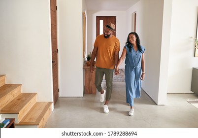 Loving African American Couple Walking Into Hall At Home Holding Hands