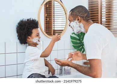 Loving African American Father and little boy having fun playing shaving foam on their faces in bathroom together, Happy African Dad and son. - Powered by Shutterstock